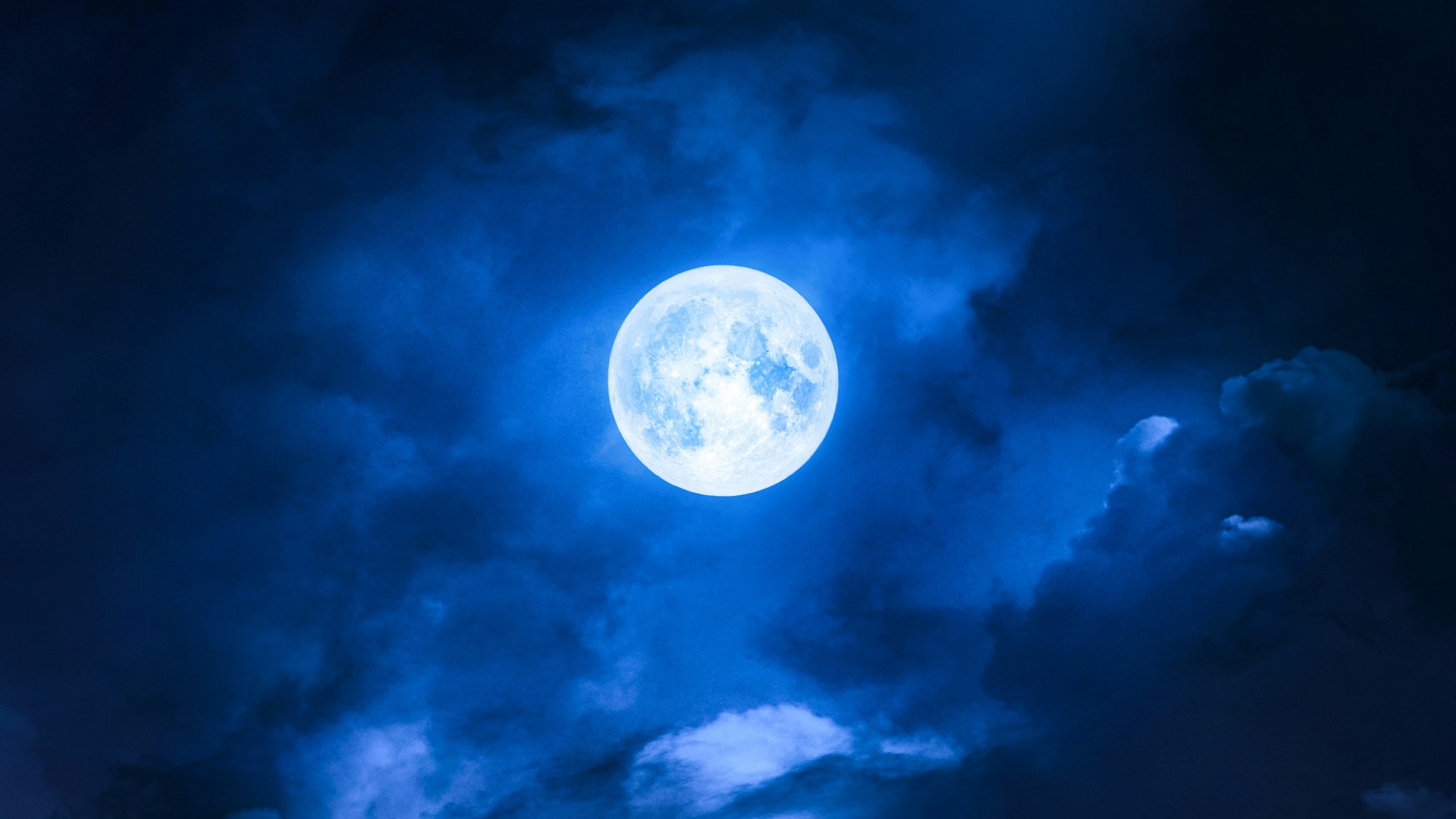 a full moon is seen through the clouds
