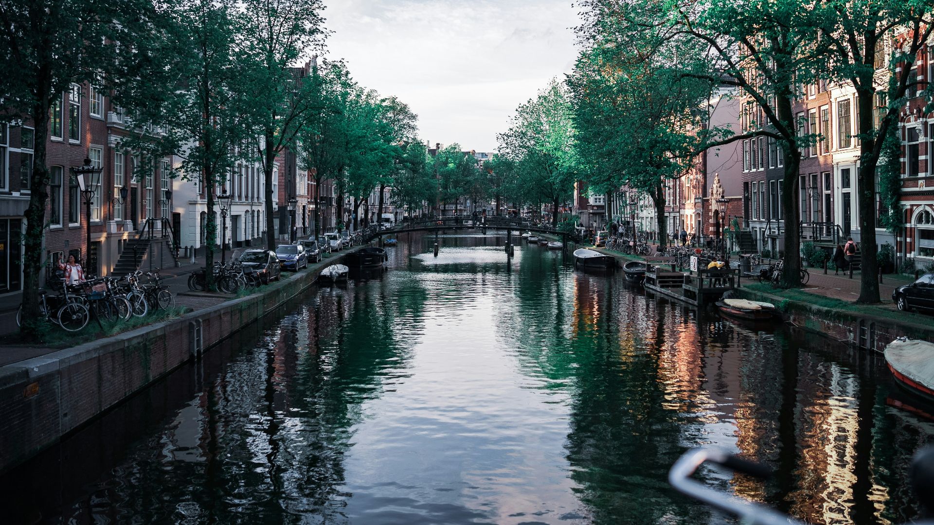 A canal in amsterdam, lined with buildings.
