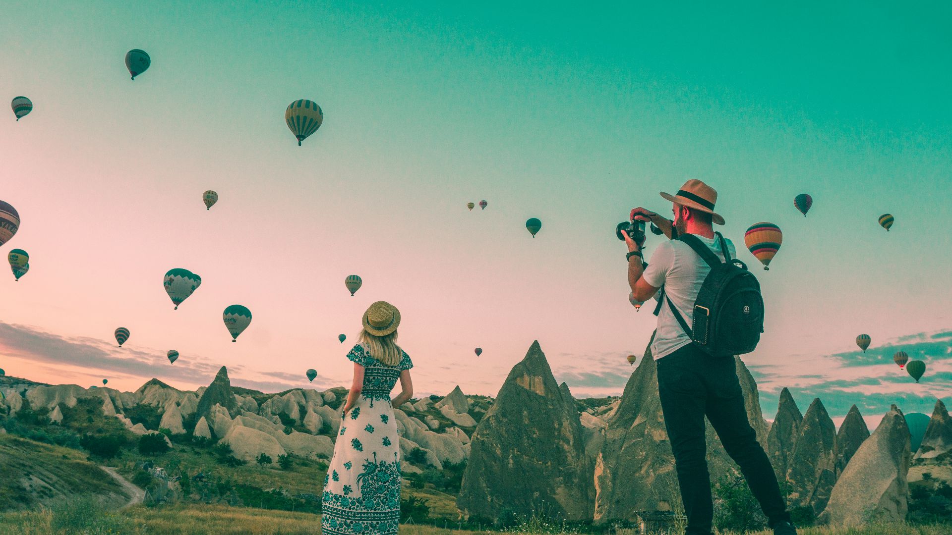 man taking photo of hot air balloons
