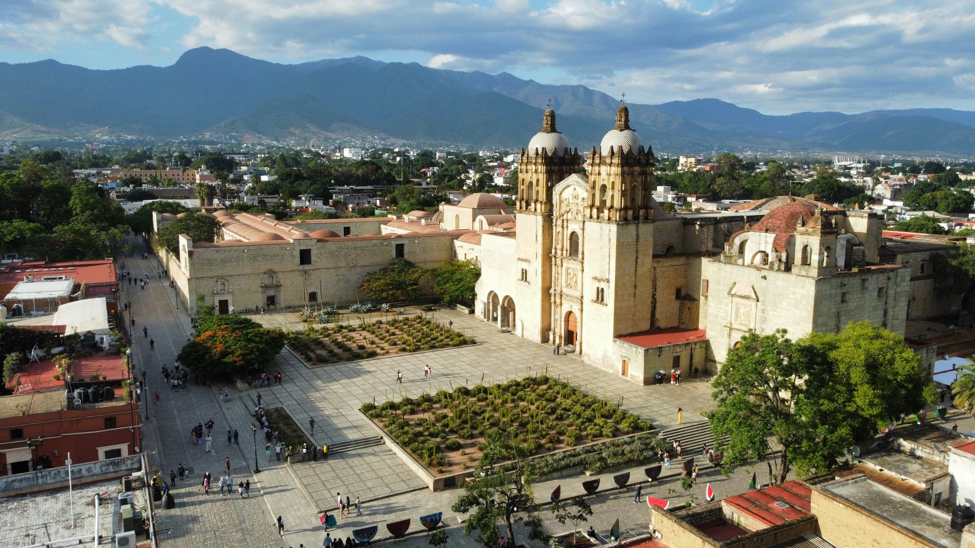 a large building with a dome and a courtyard with people walking around