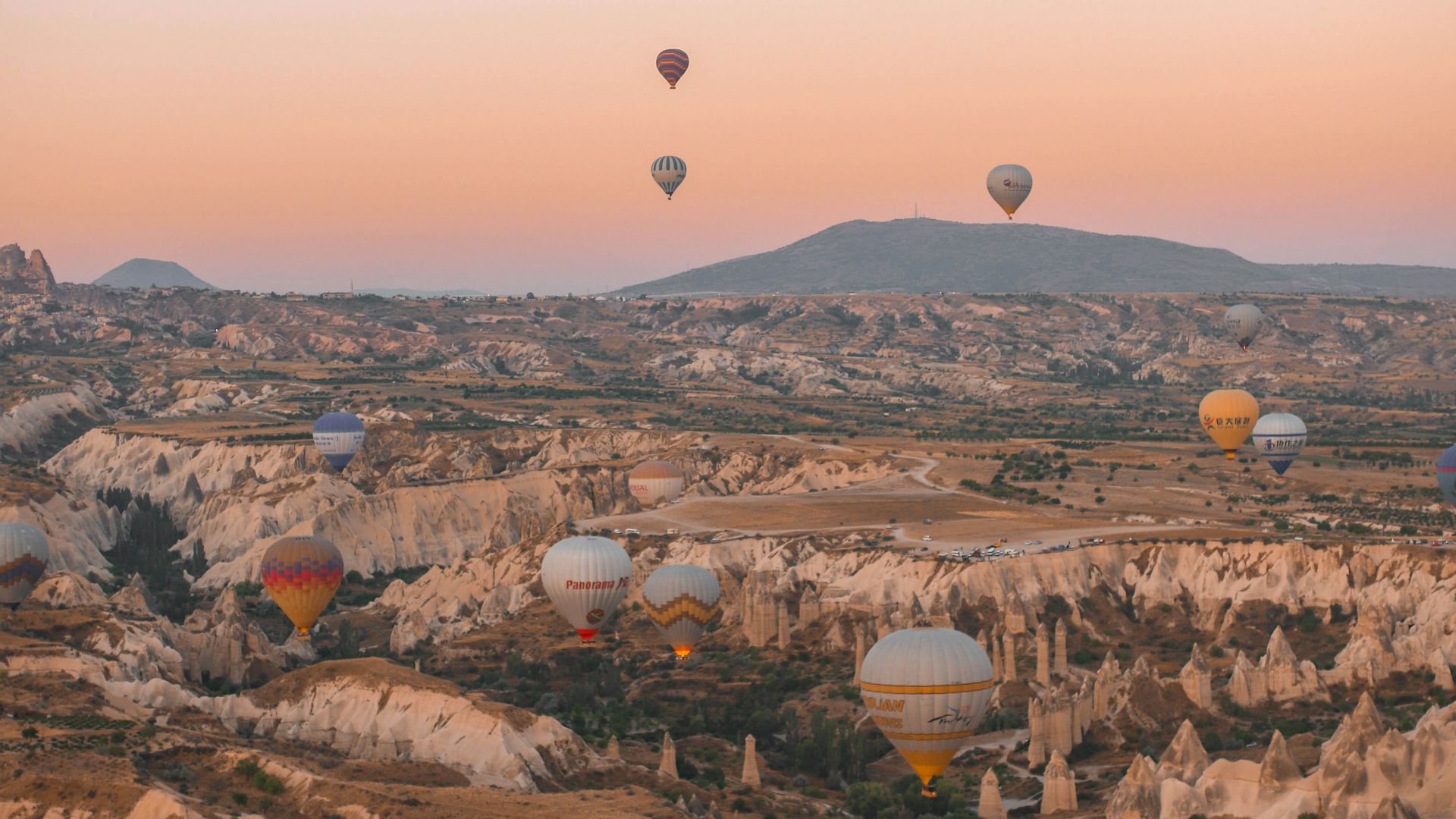 a group of hot air balloons flying over a valley