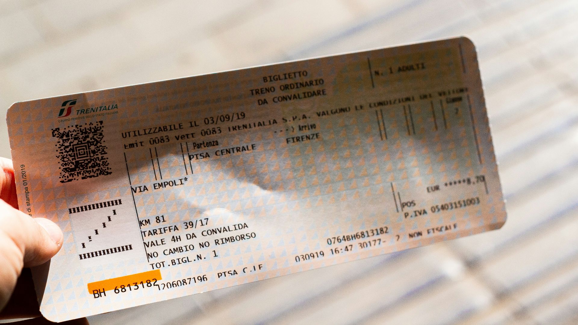 A person holding up a ticket for a concert