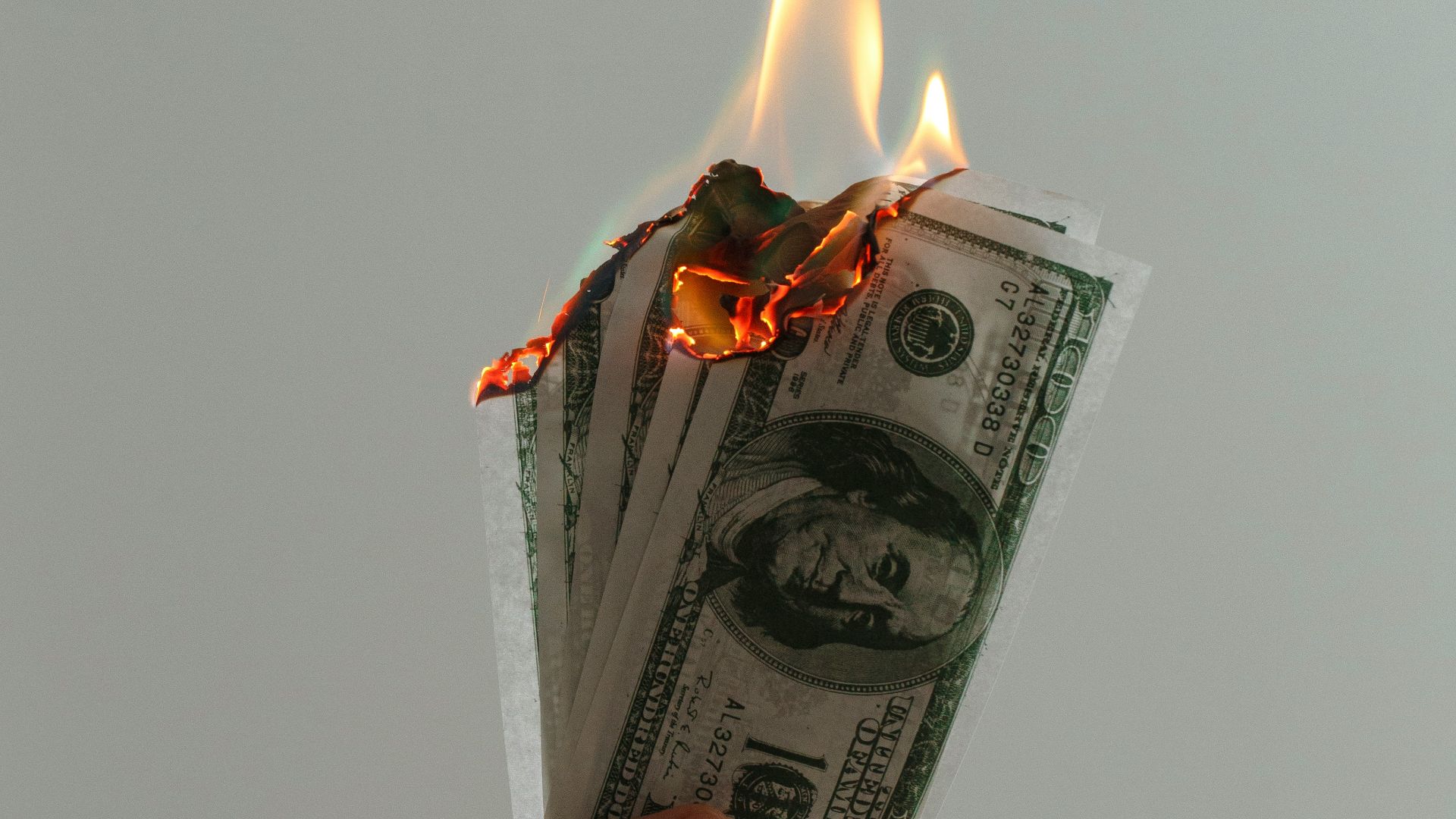 time lapse photography of several burning US dollar banknotes
