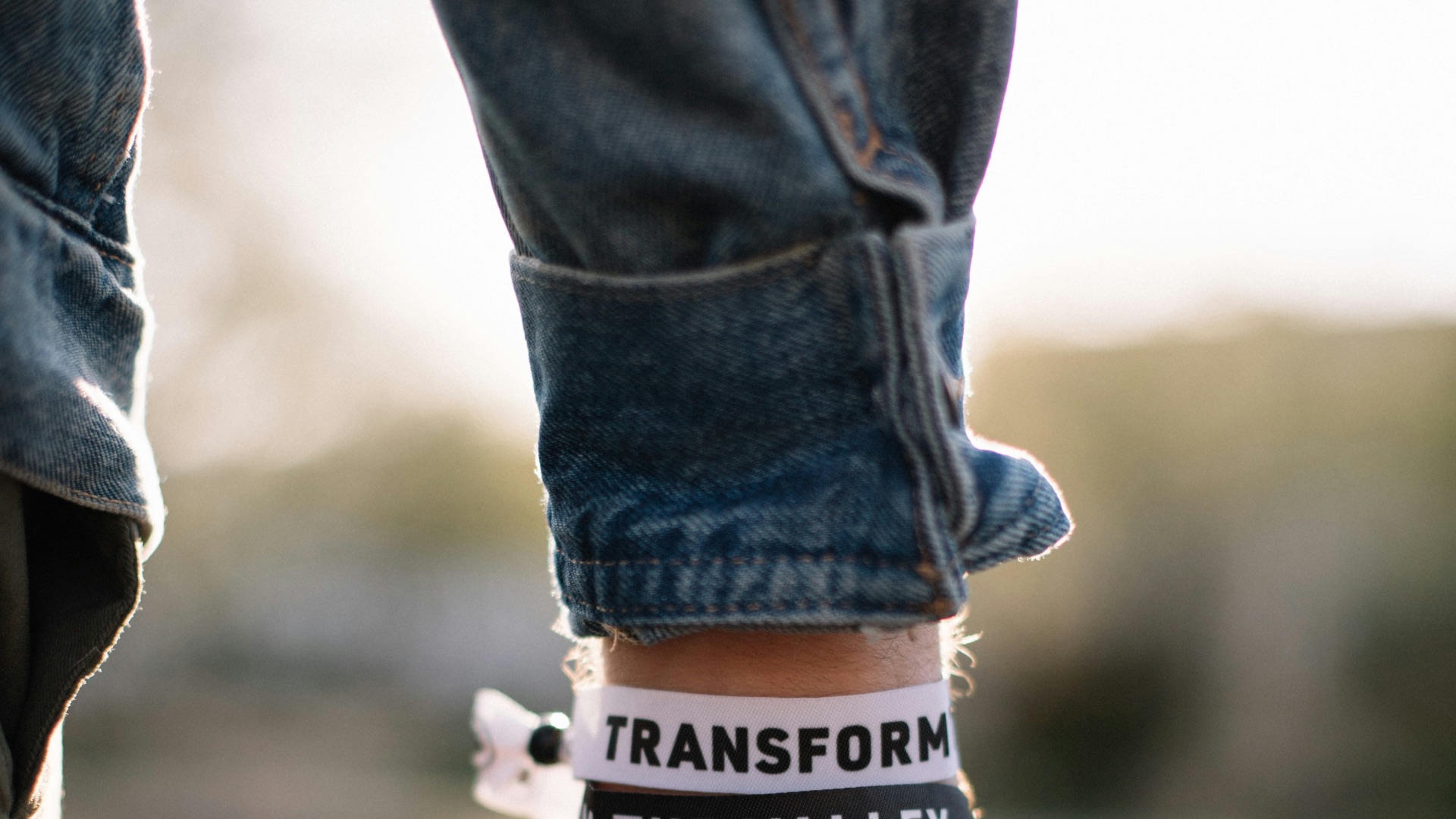 person in blue denim jeans with black and white happy birthday print bracelet