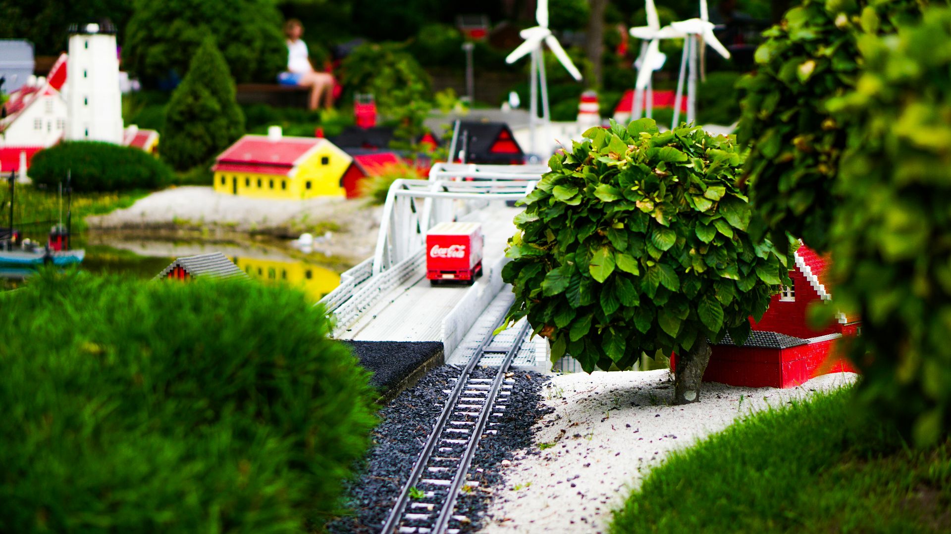 a model of a train track with a tree and windmills in the background