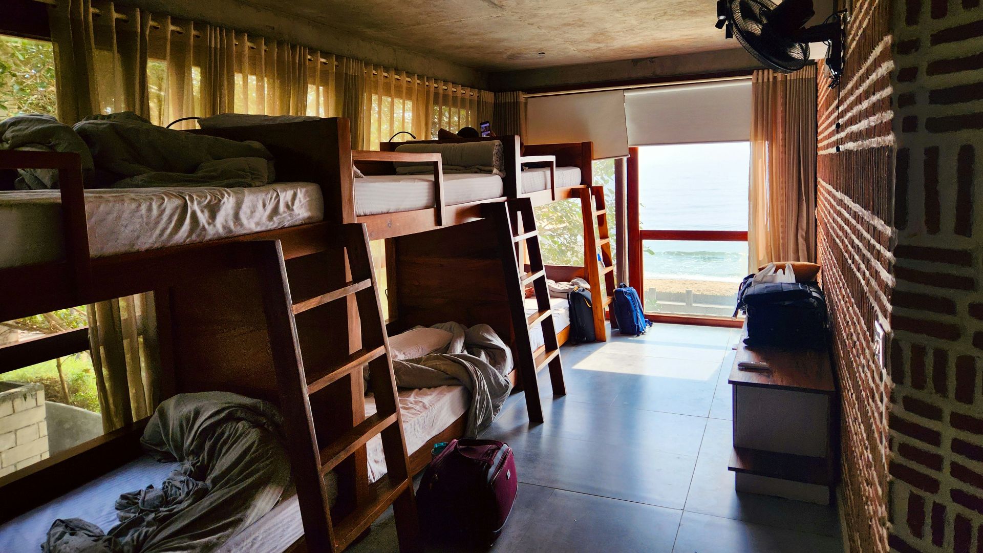 a room filled with lots of bunk beds next to a window