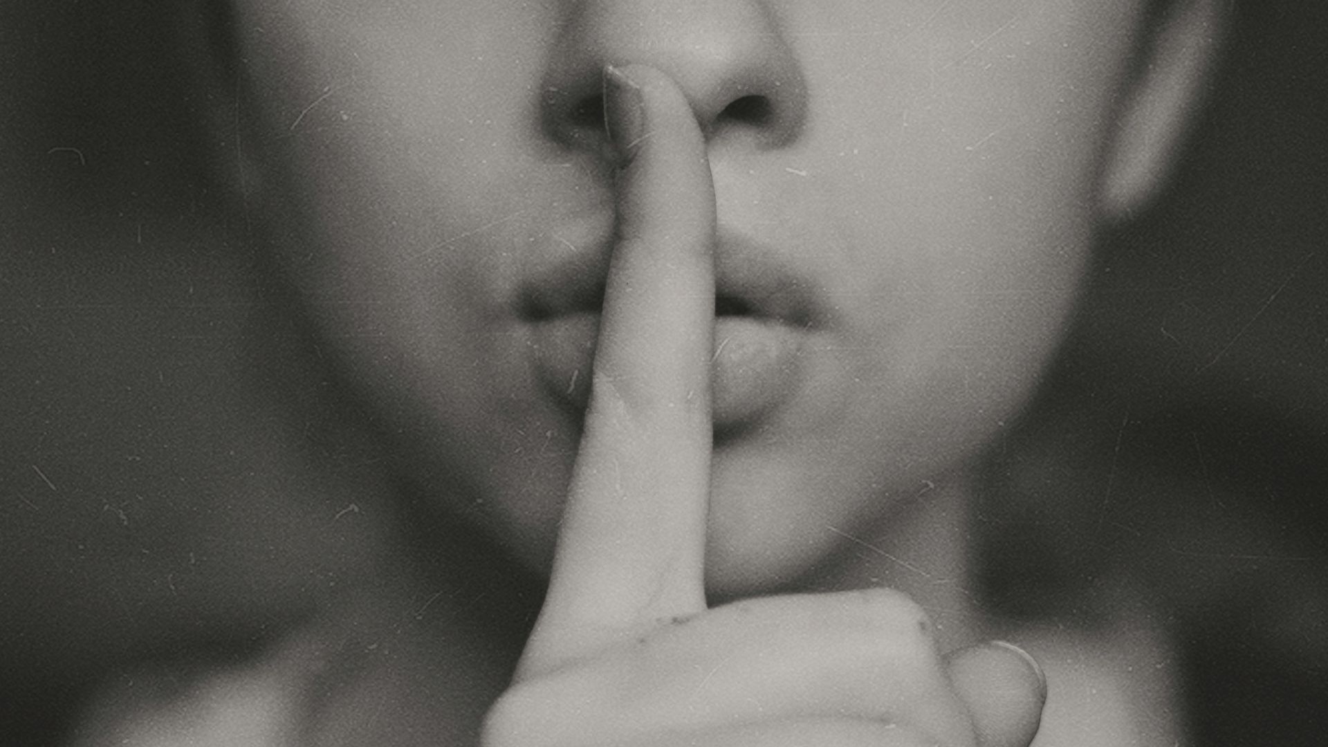 grayscale photo of woman doing silent hand sign