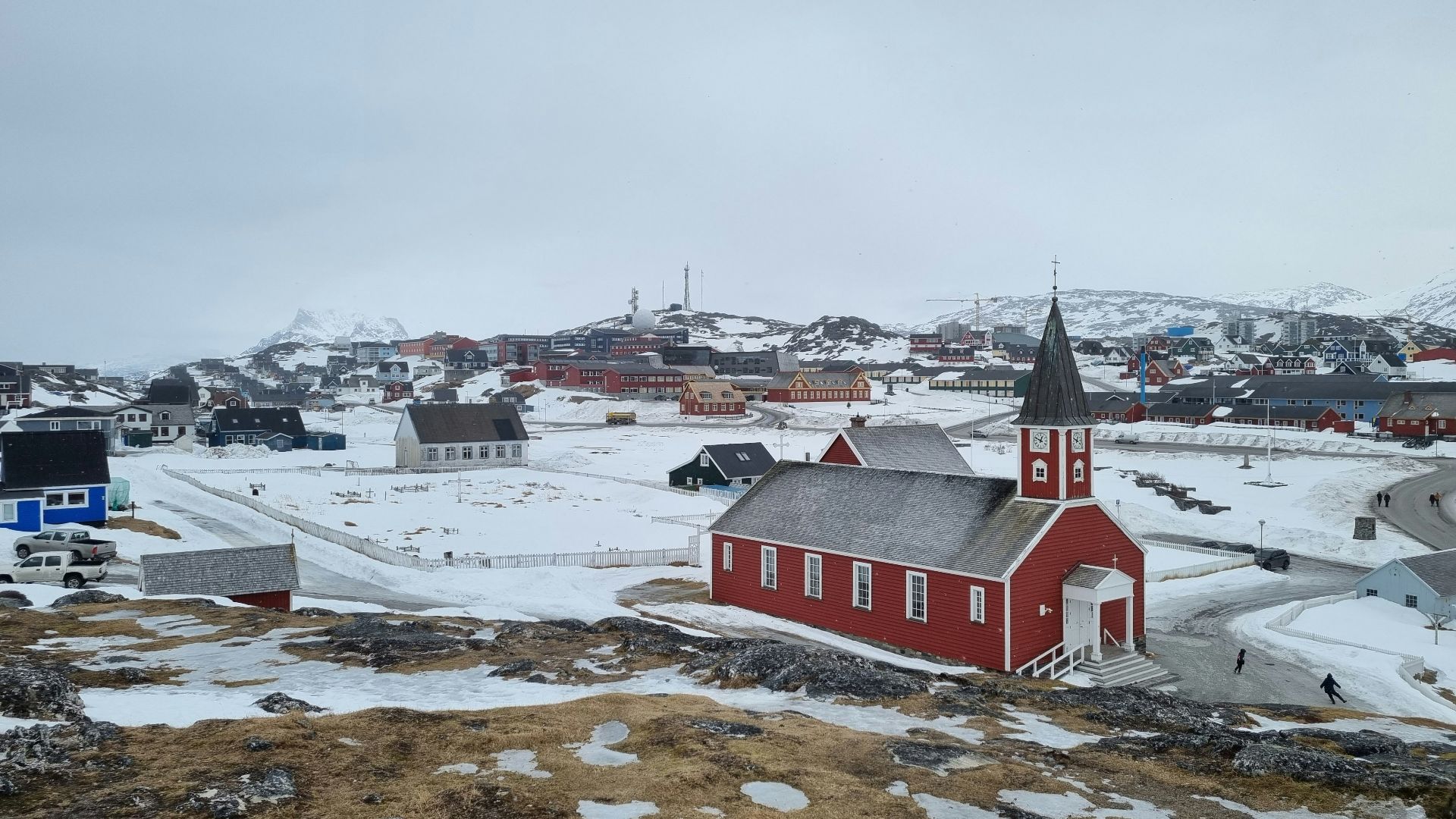 a small red church on a snowy hill
