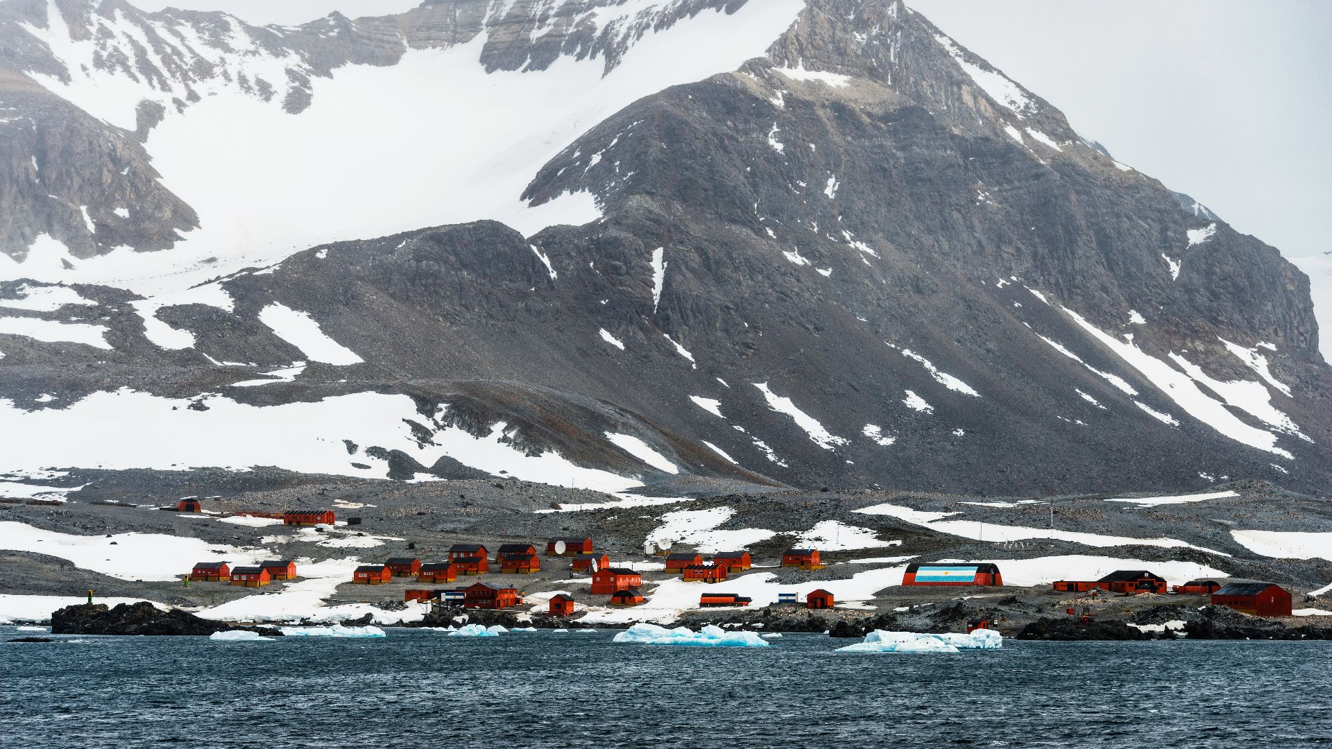 a snow covered mountain with a village in the foreground