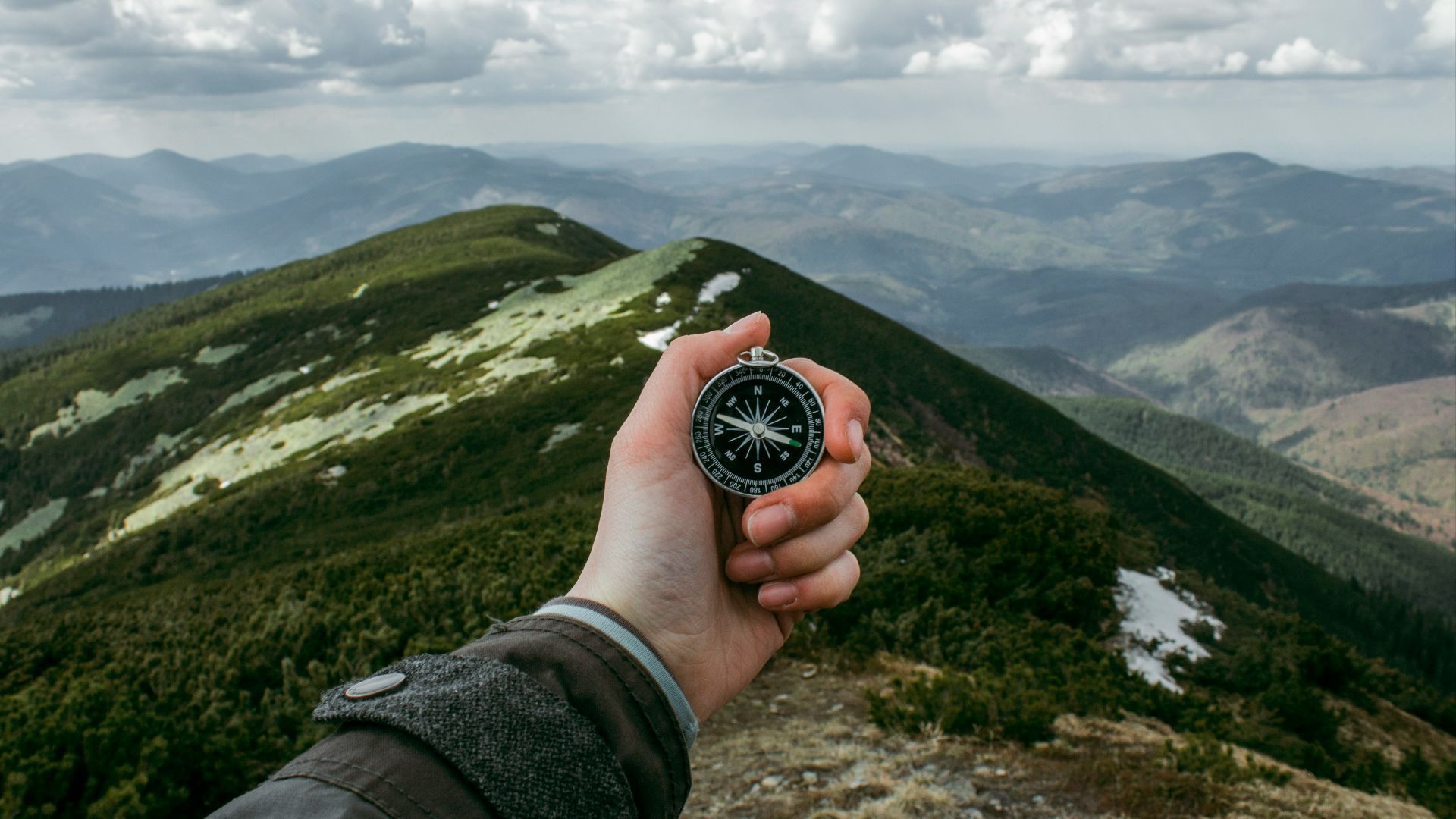 person holding silver compass