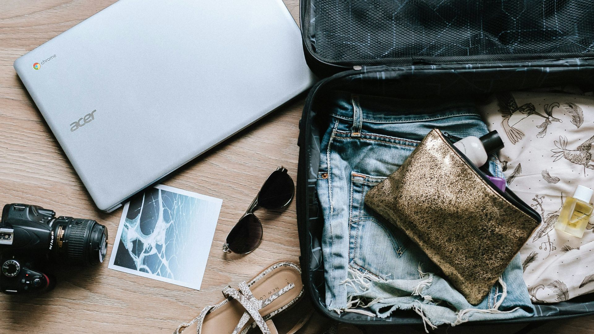 black DSLR camera near sunglasses and bag