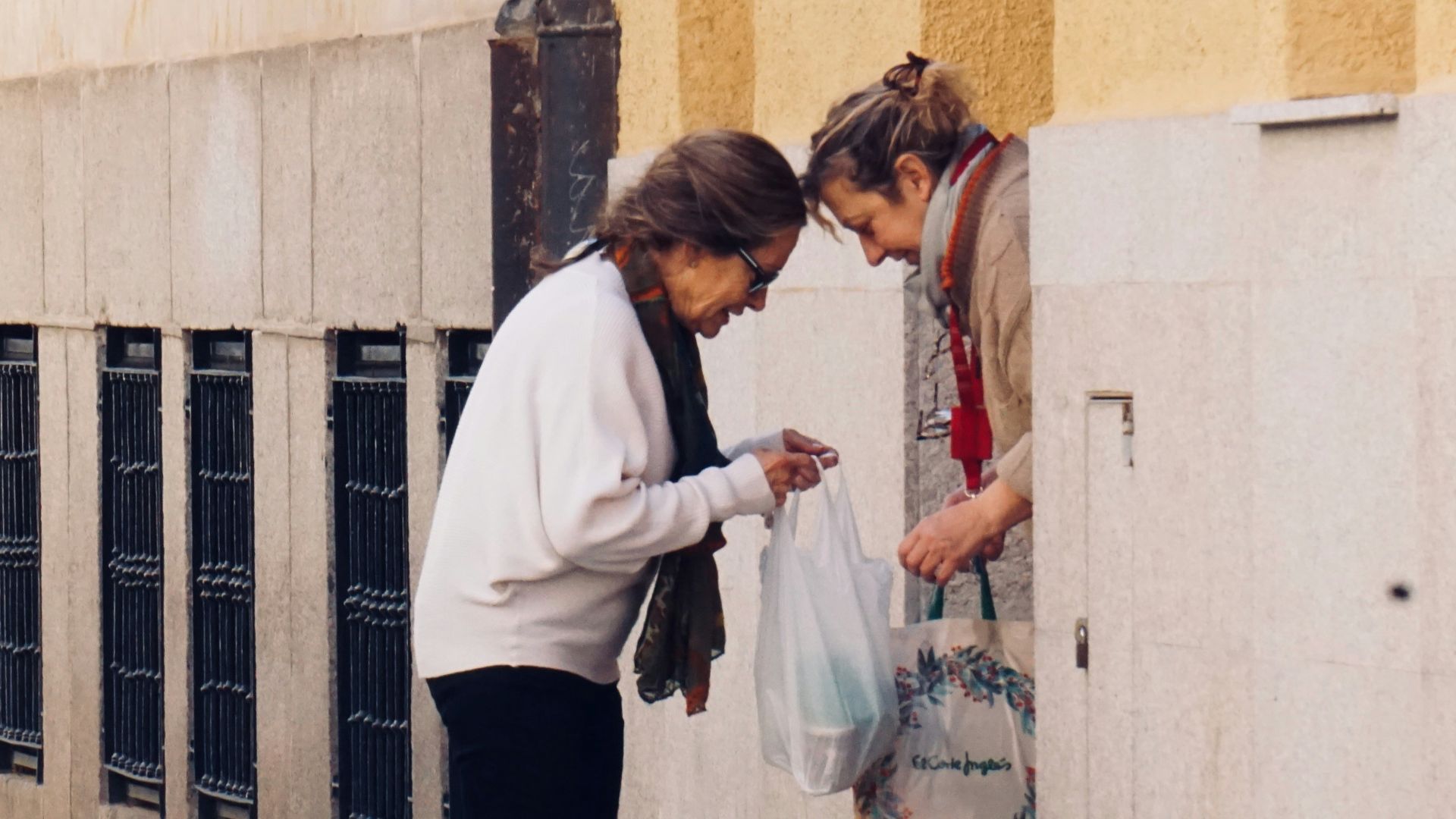 woman in white long sleeve shirt and black pants standing on sidewalk during daytime