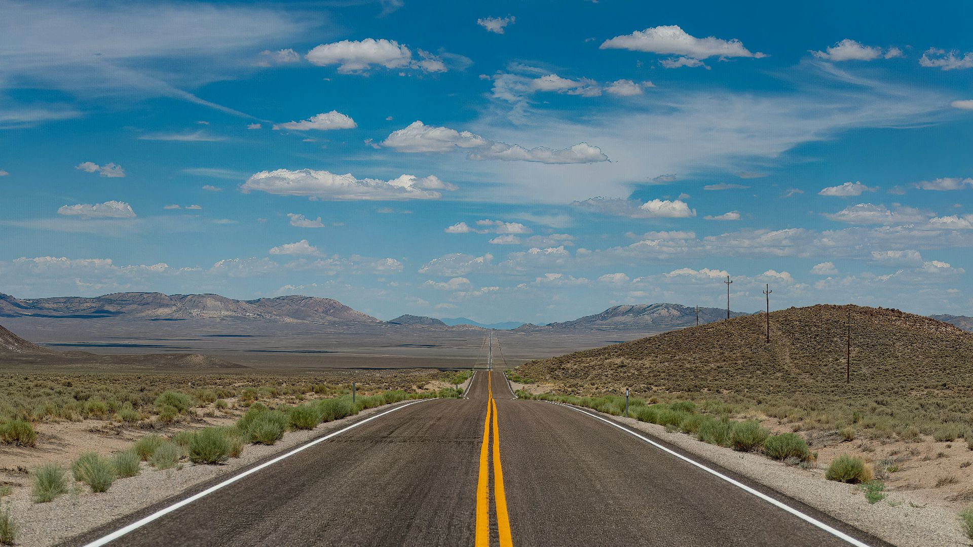 A desert road stretches towards the horizon.