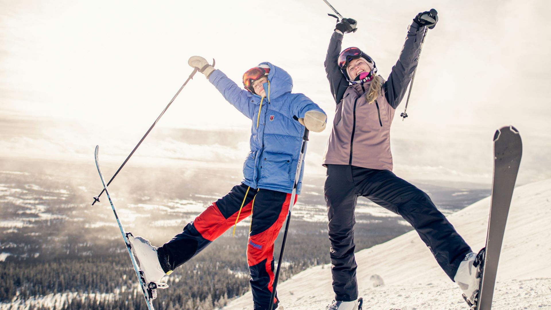 2 person in white pants and black snow ski blades standing on snow covered ground during