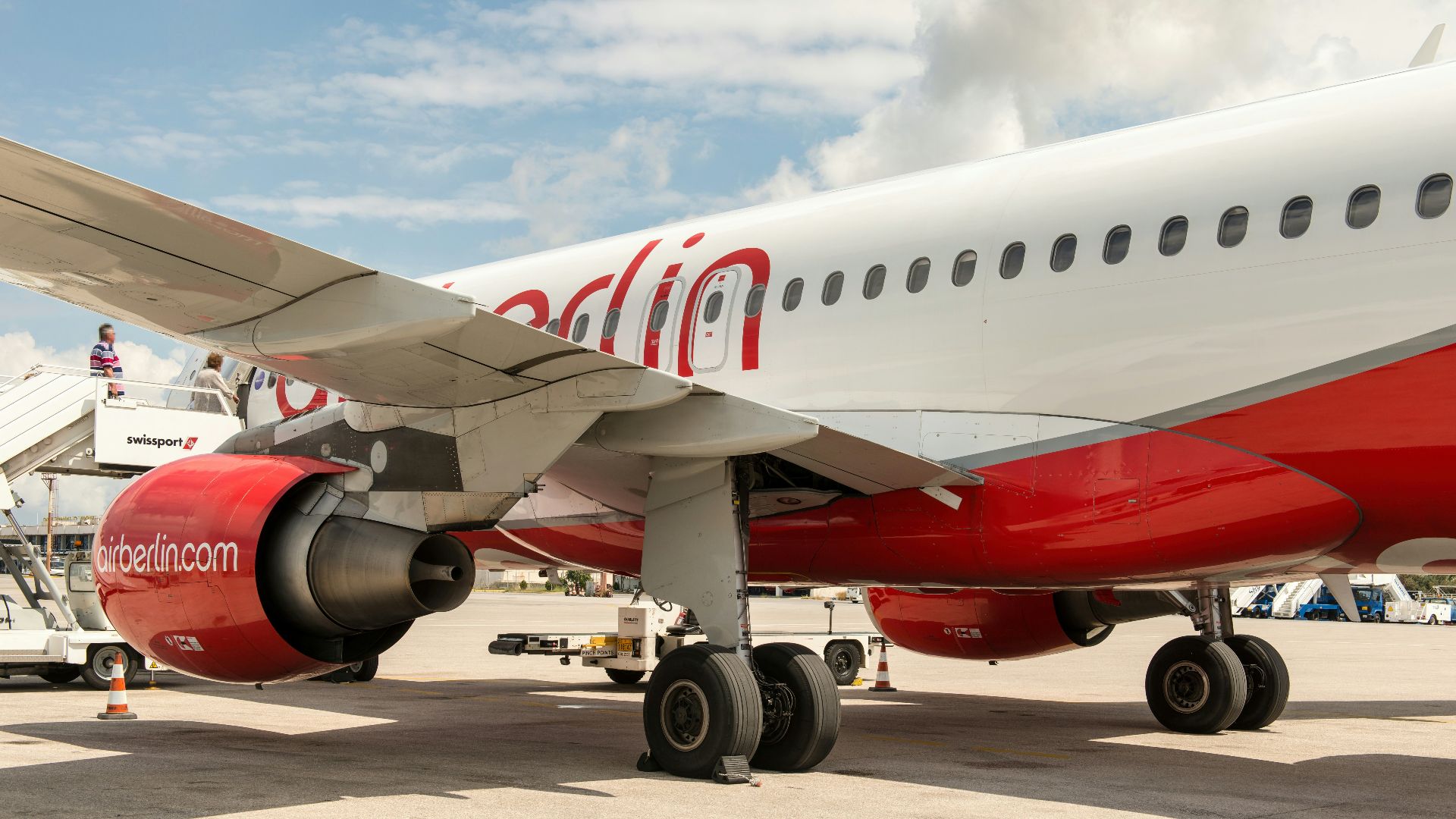 Close-up of a red and white airplane engine and wing.