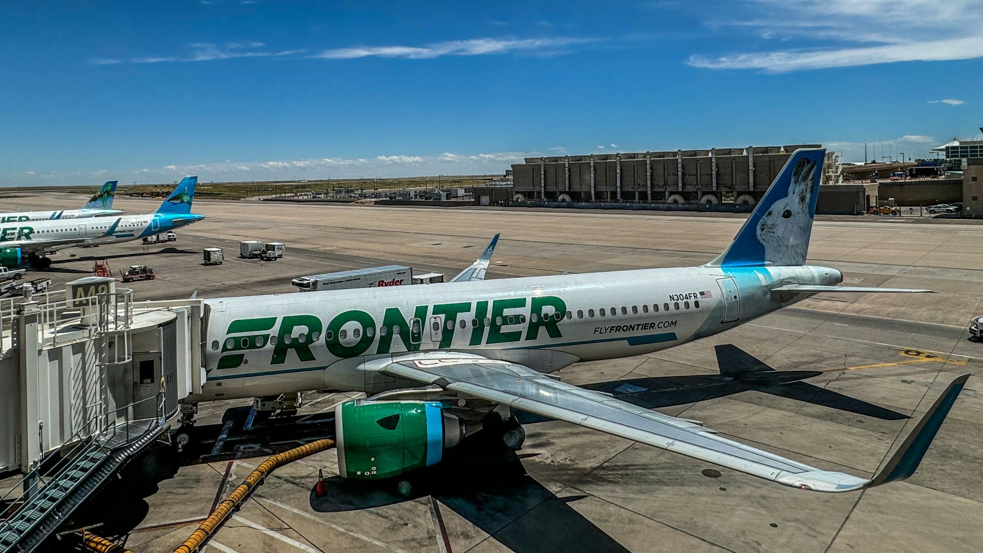 A frontier airplane parked on the tarmac at an airport