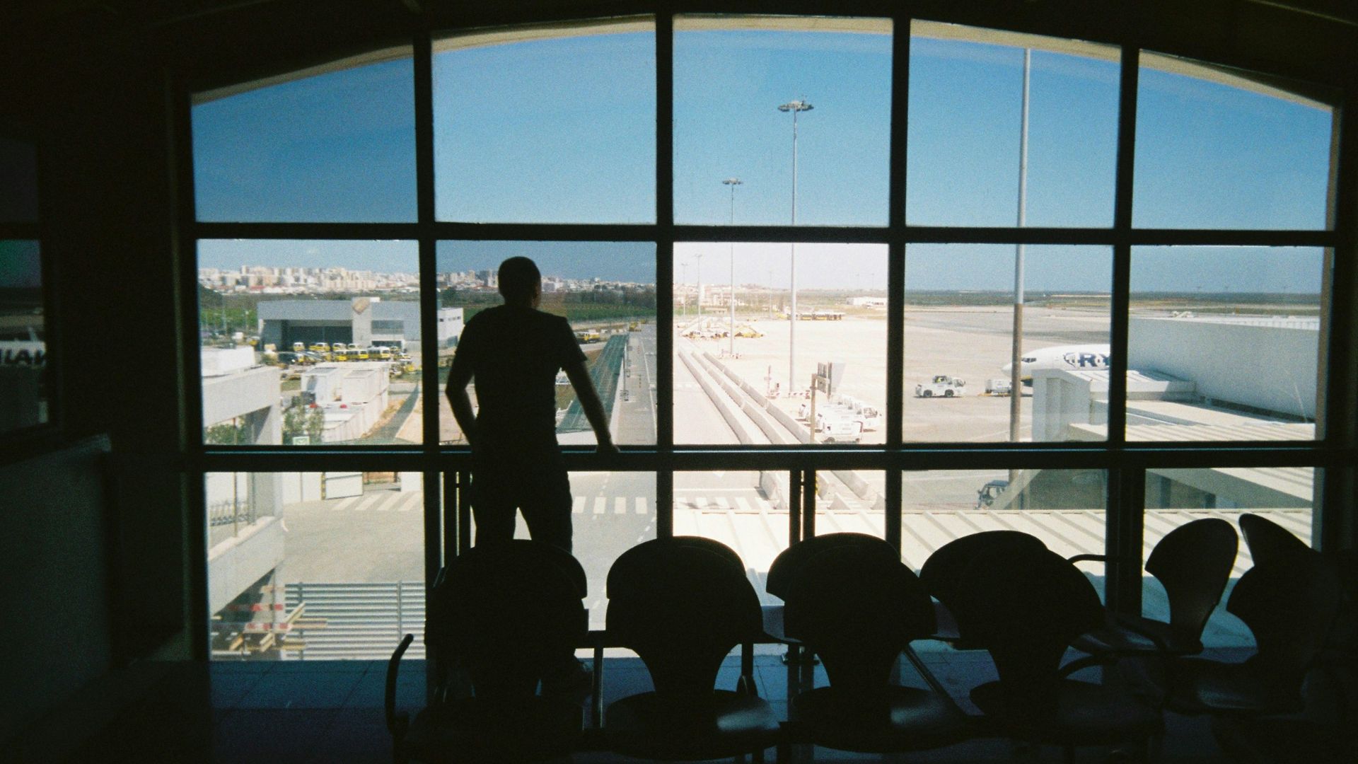 silhouette of man standing near glass window