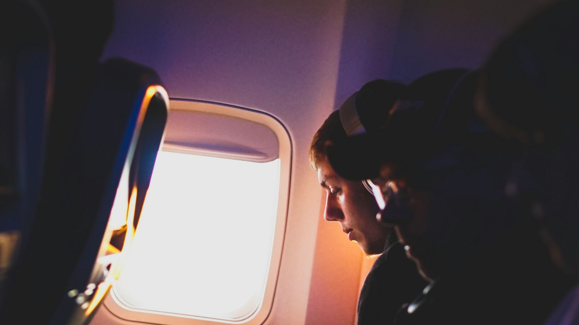photo of three people listening to music inside airplane