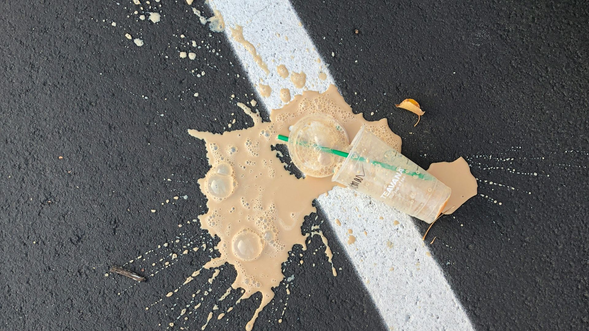 person standing on white line with cup on ground