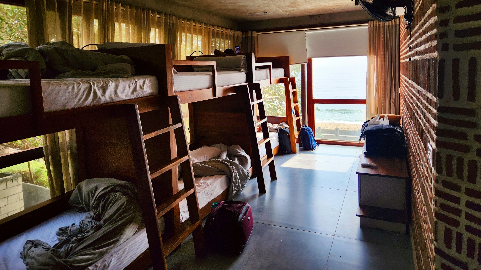 a room filled with lots of bunk beds next to a window