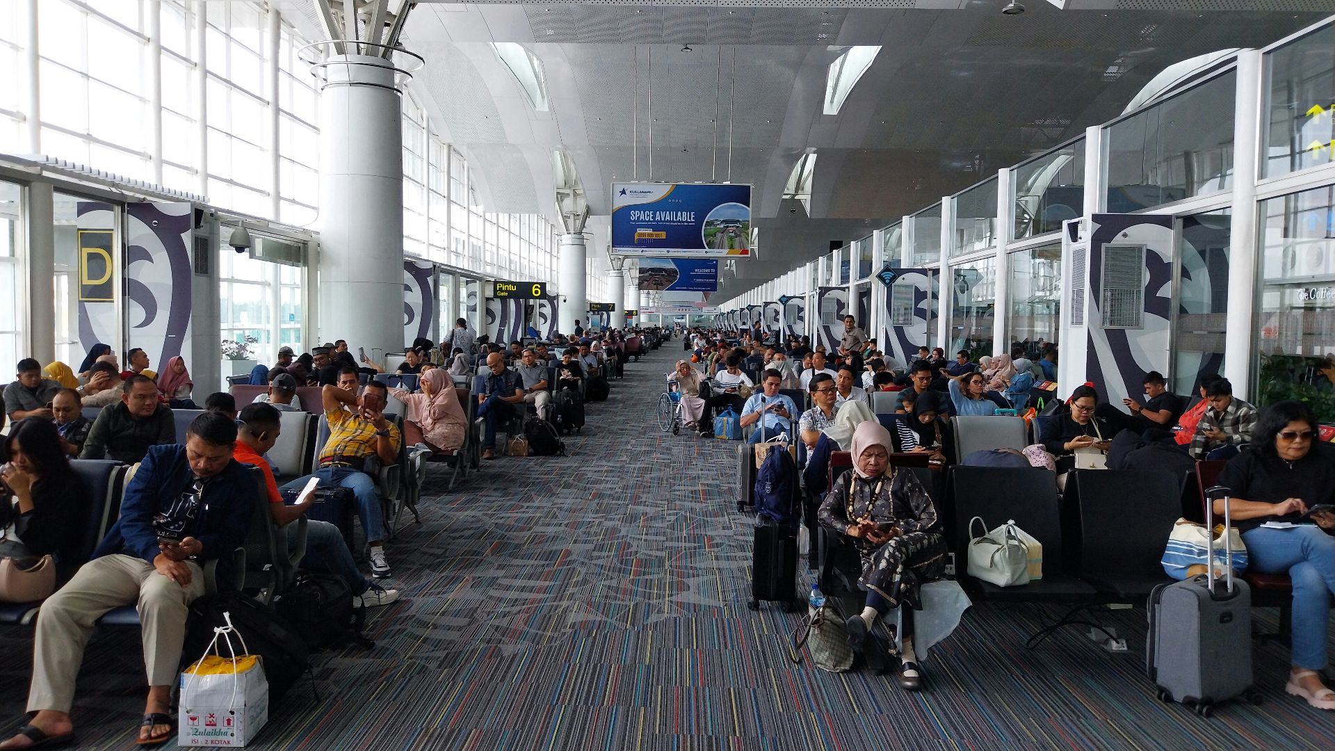 A large group of people waiting for their luggage