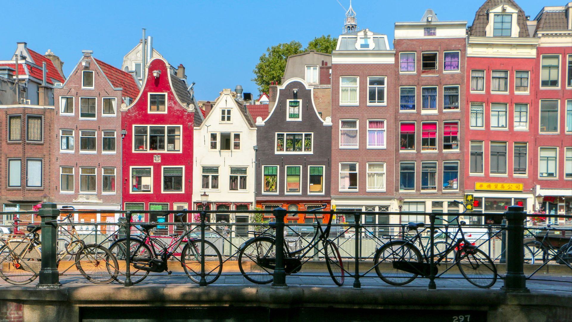 black bicycle leaning on black metal fence