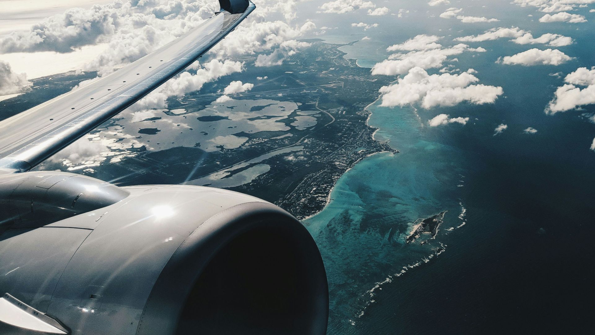 photo of airplane wing under blue sky at daytime