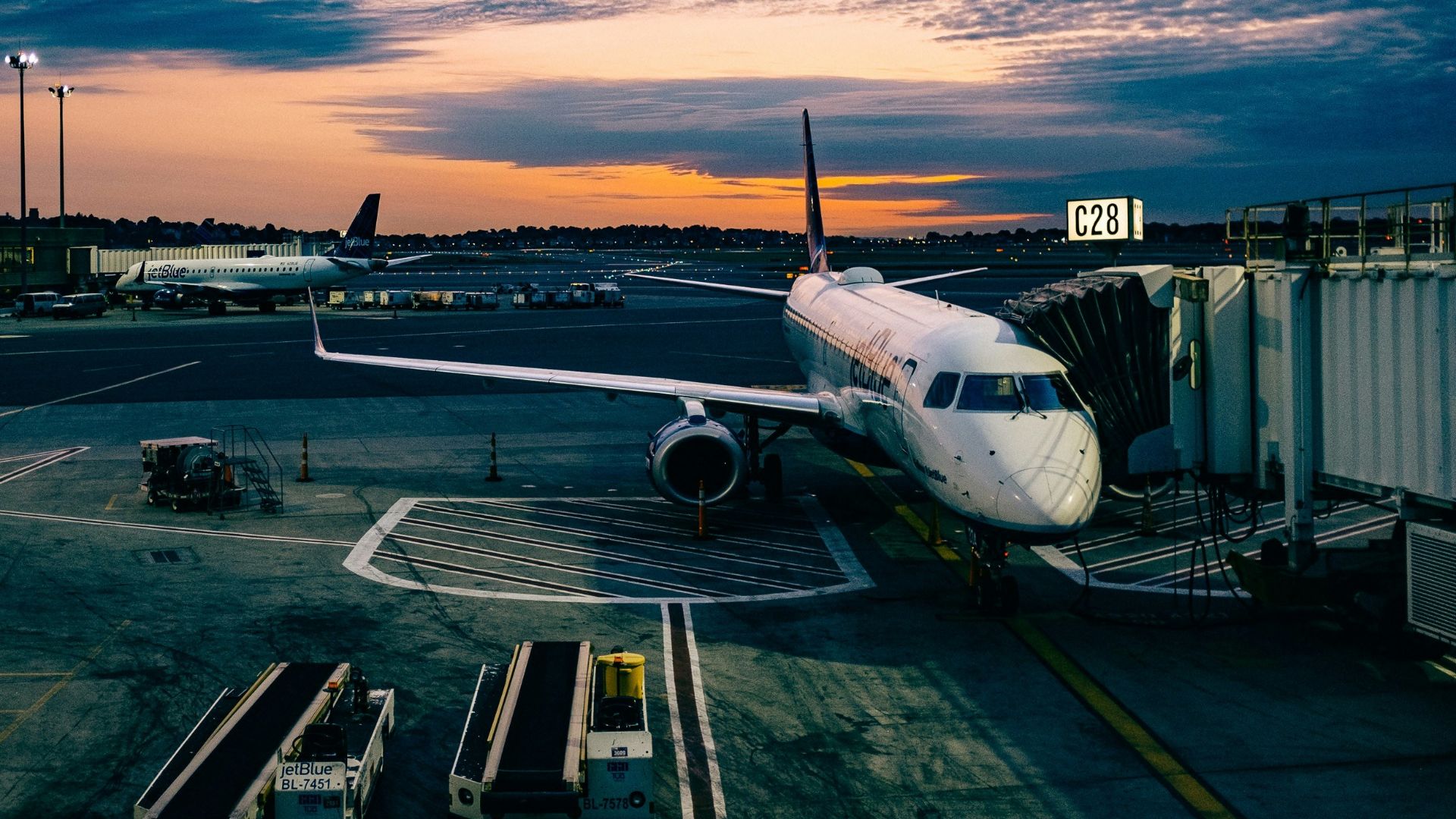 white airplane near trailers during sunset