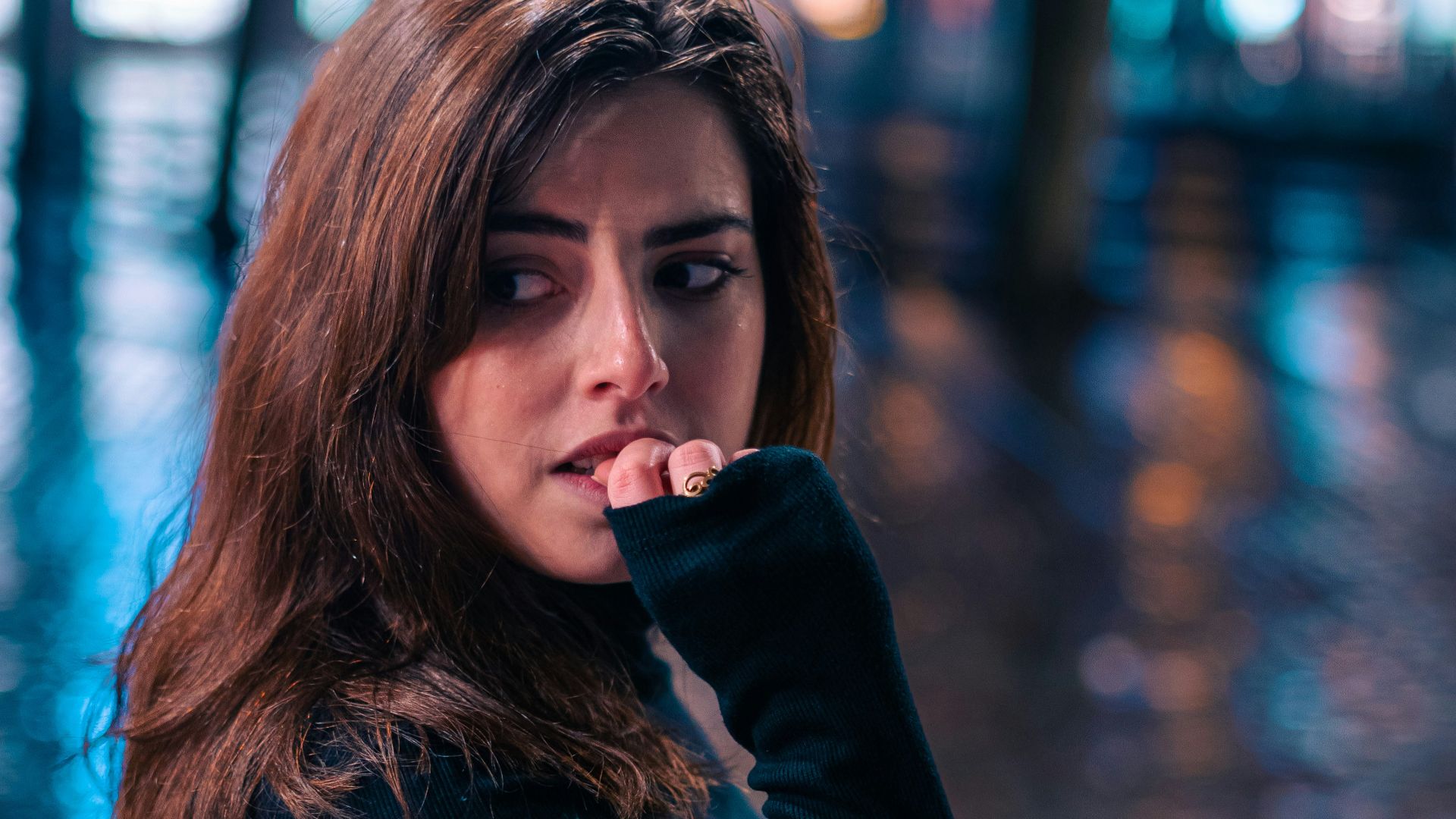 a woman standing on a sidewalk in the rain