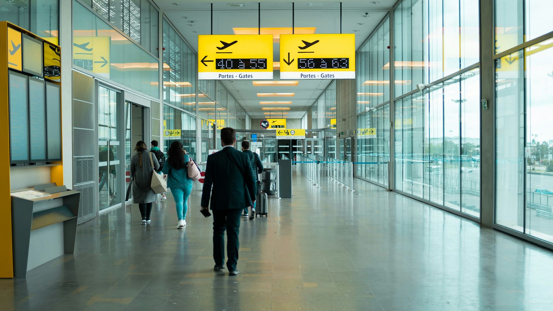 man in black jacket walking on hallway