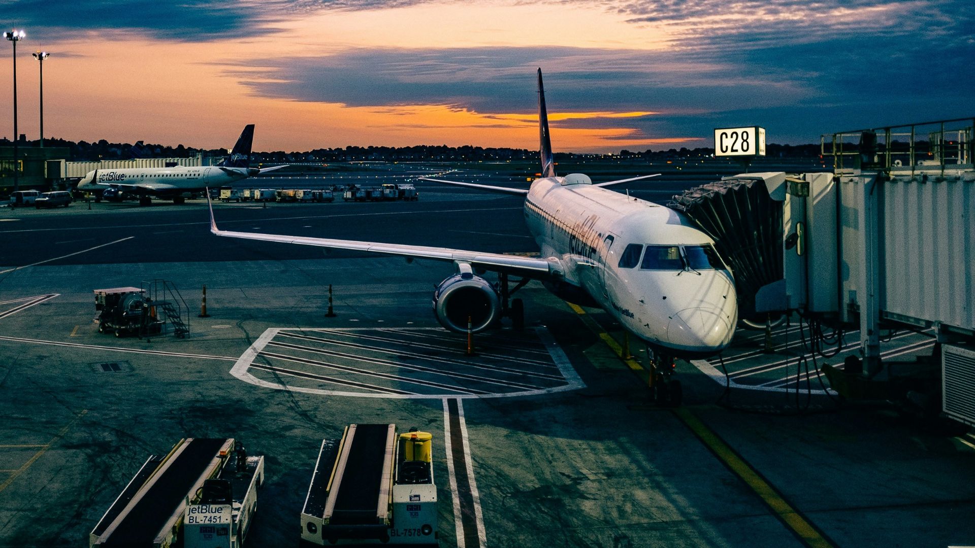 white airplane near trailers during sunset