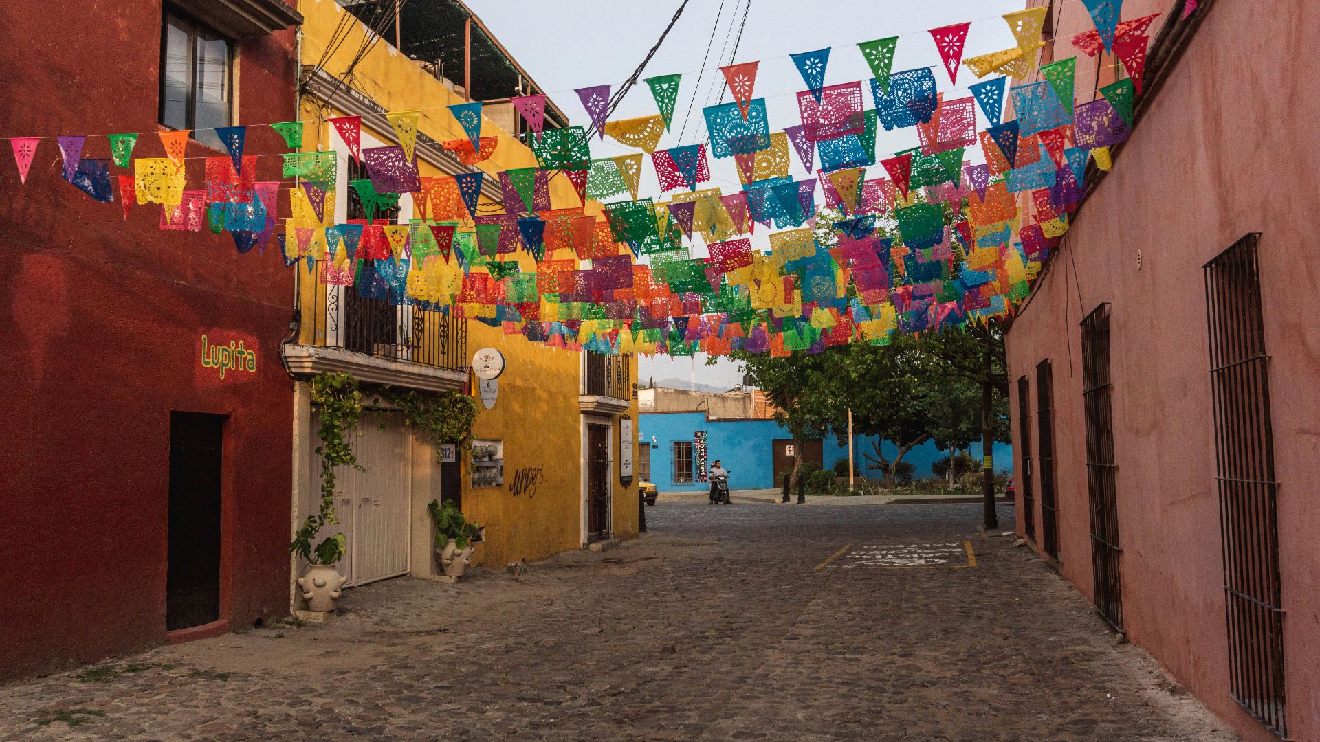 a street lined with colorful flags and buildings