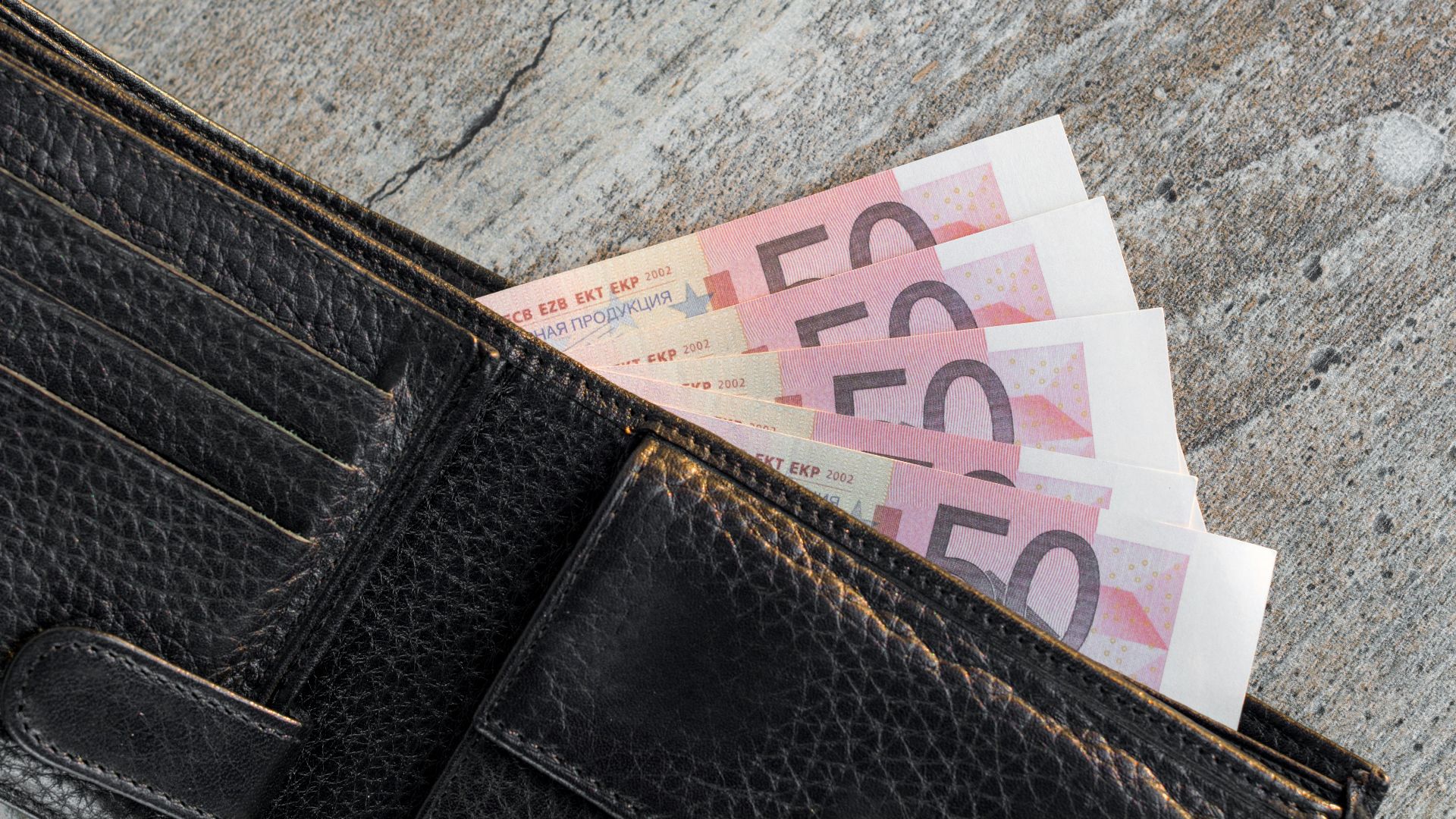 a wallet with a bunch of money sticking out of it