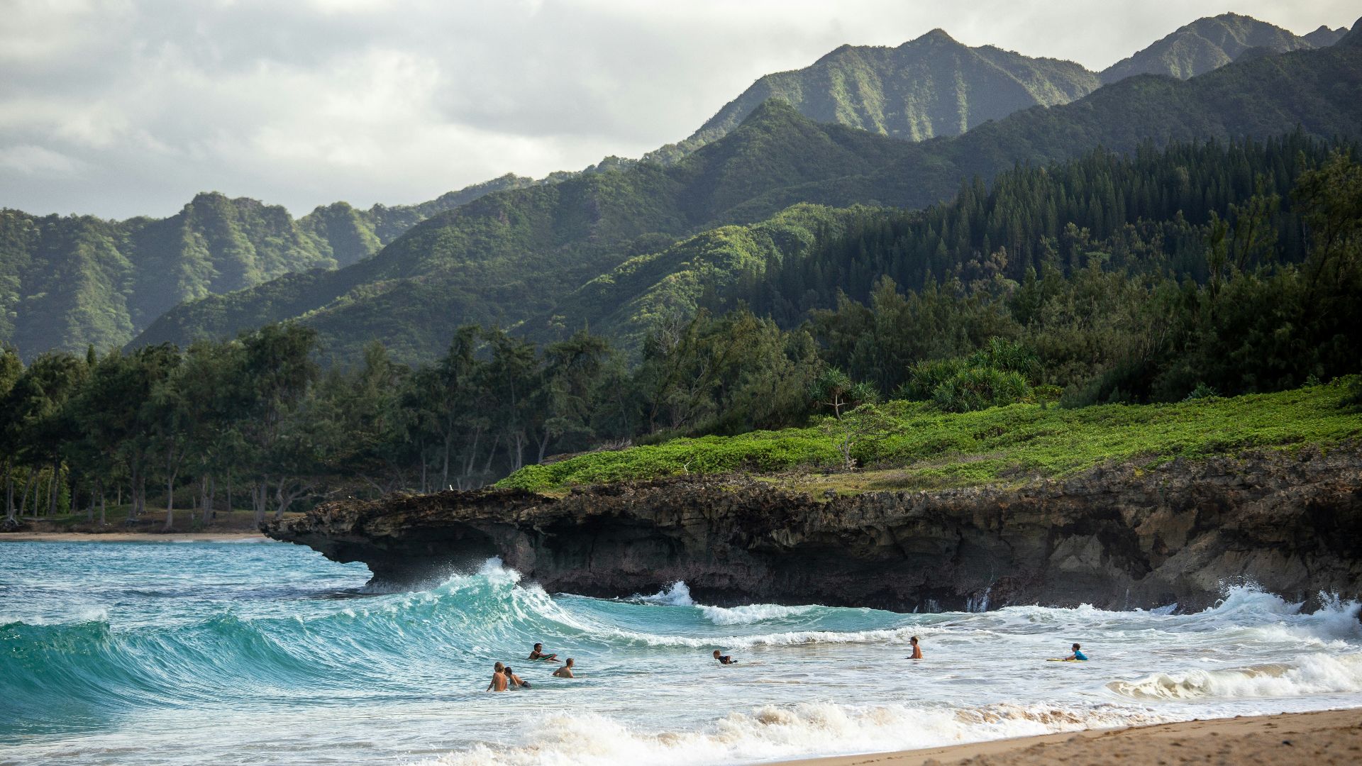 people swimming near shore with waves during daytime