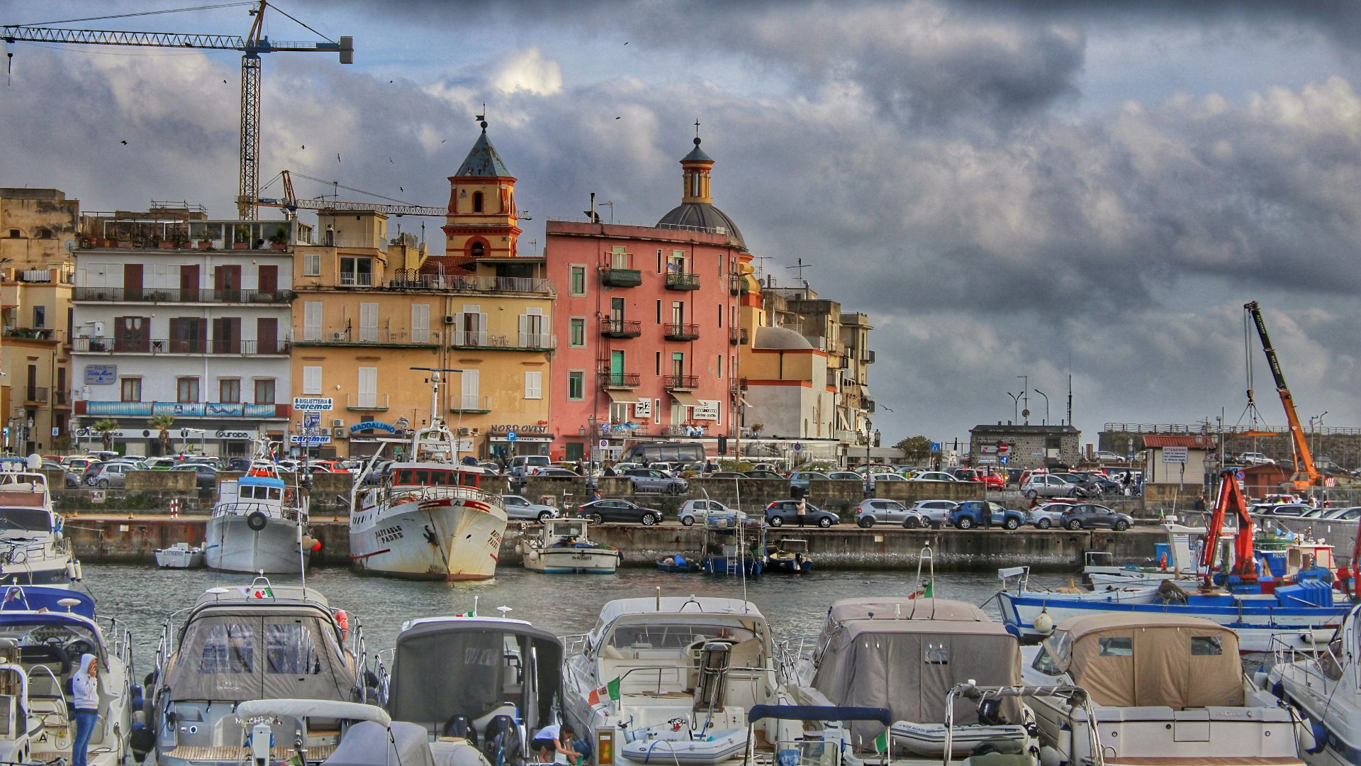 a harbor filled with lots of boats under a cloudy sky
