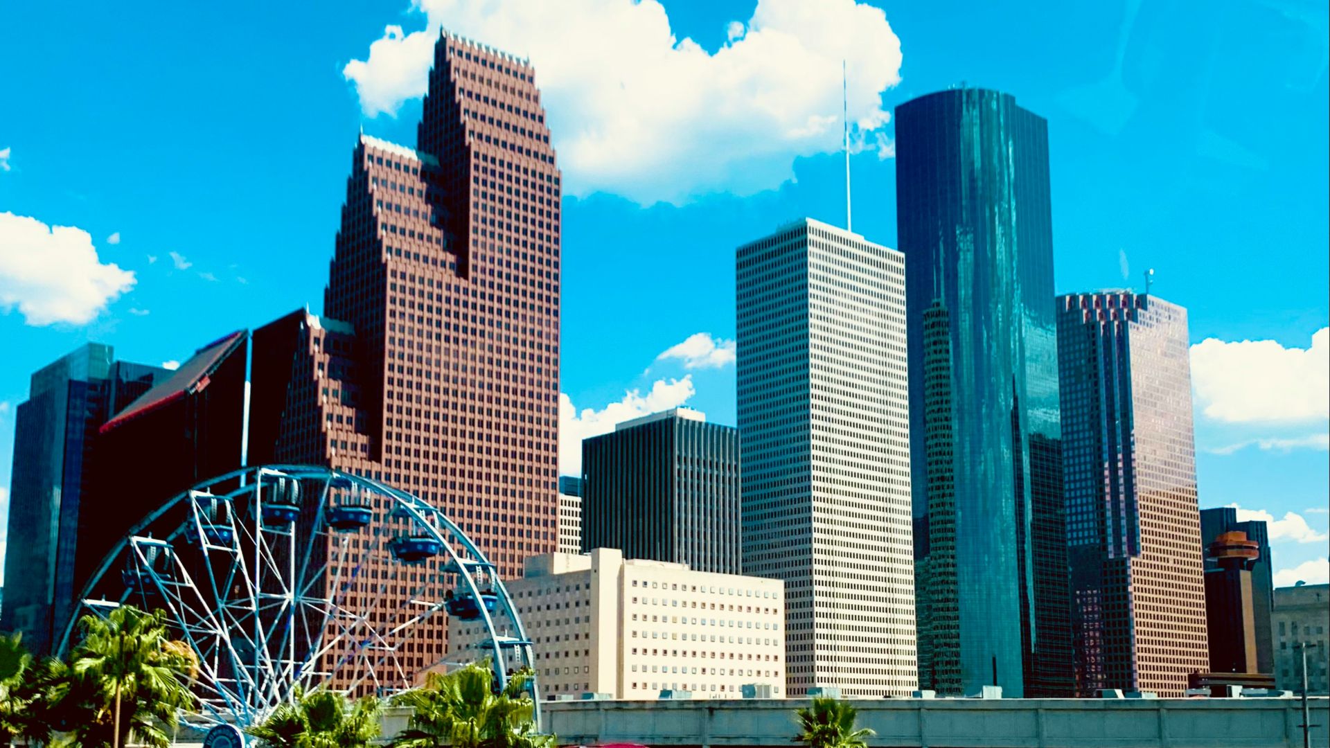 a city skyline with a ferris wheel in the foreground