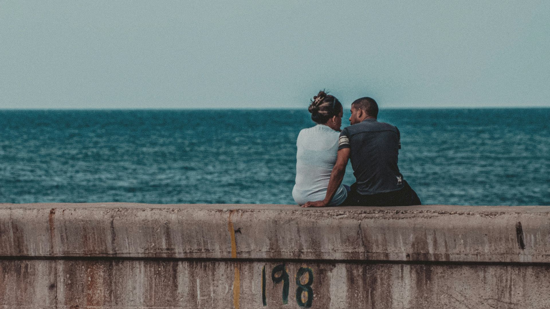couple kissing on brown wooden dock during daytime