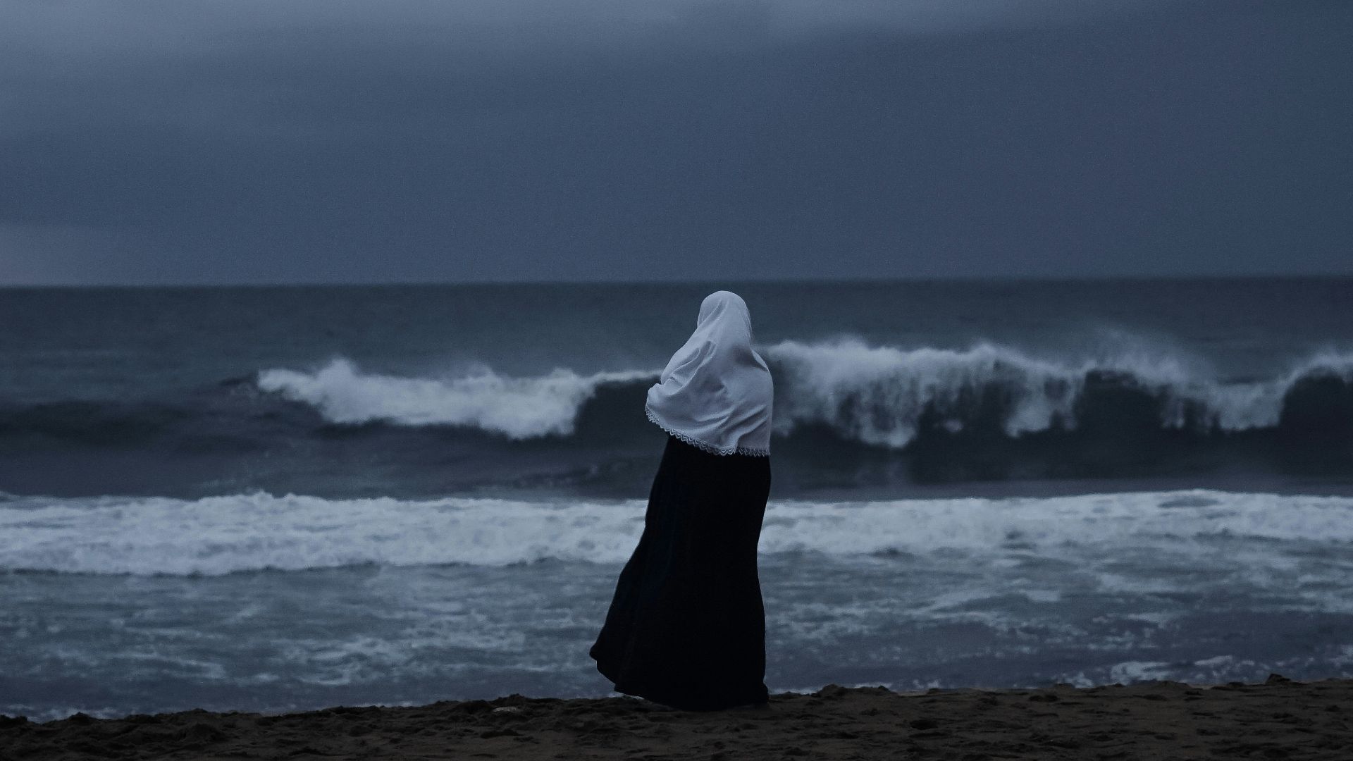 a person sitting on a beach looking at the ocean