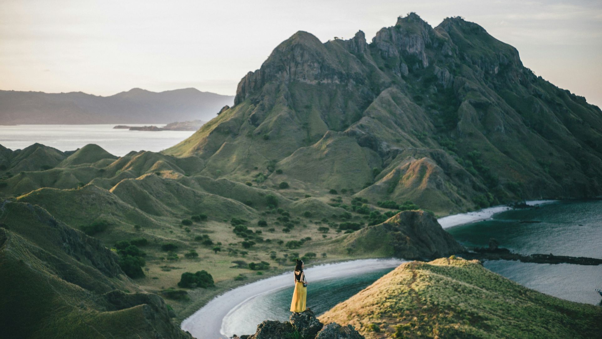 woman standing on mountain near body of water