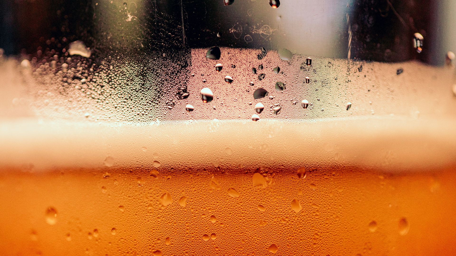 a close up of a glass of beer with drops of water