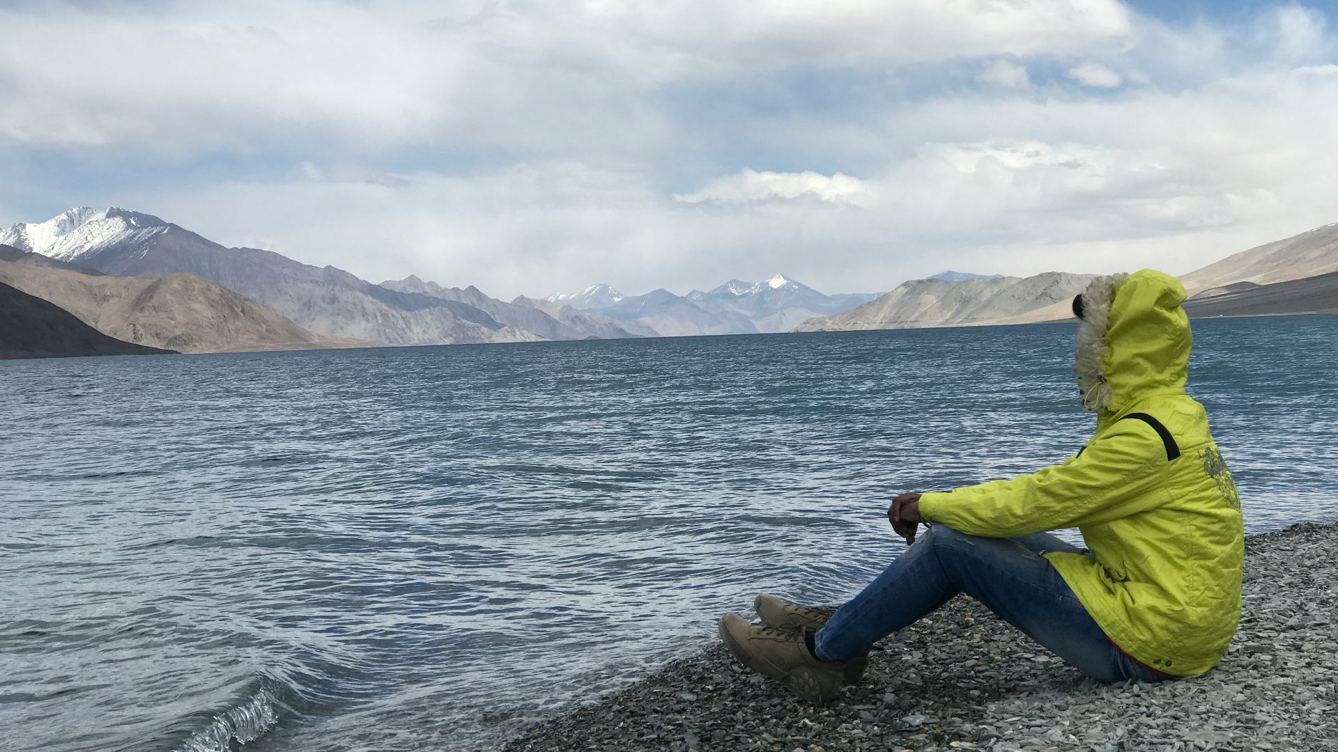 man sitting in front of body of water