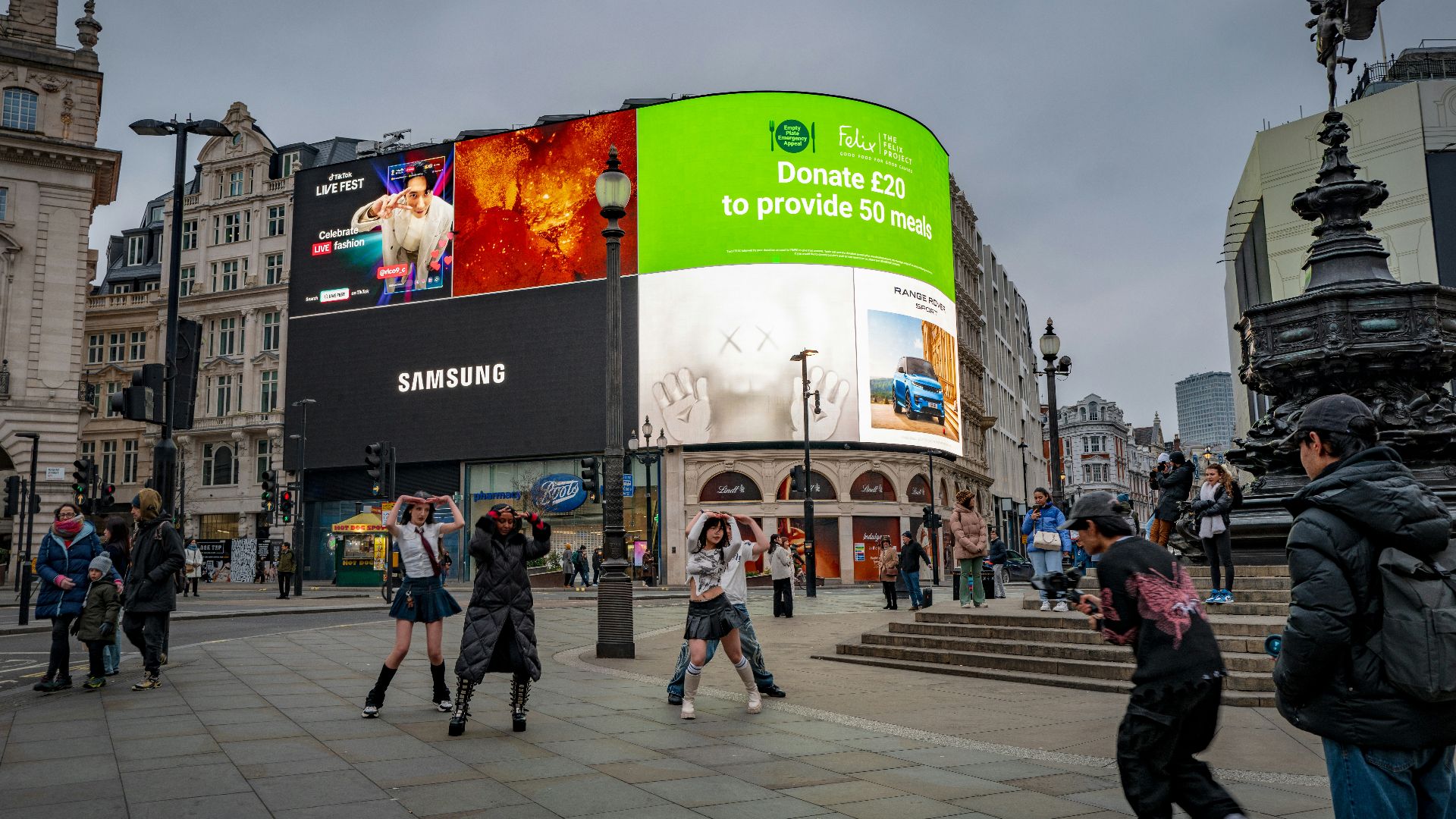 A crowd of people walking around a city square