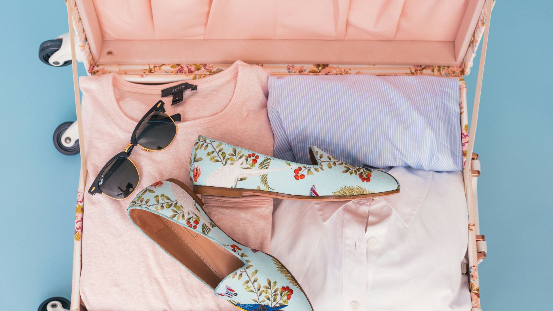 clothing items and pair of shoes in luggage