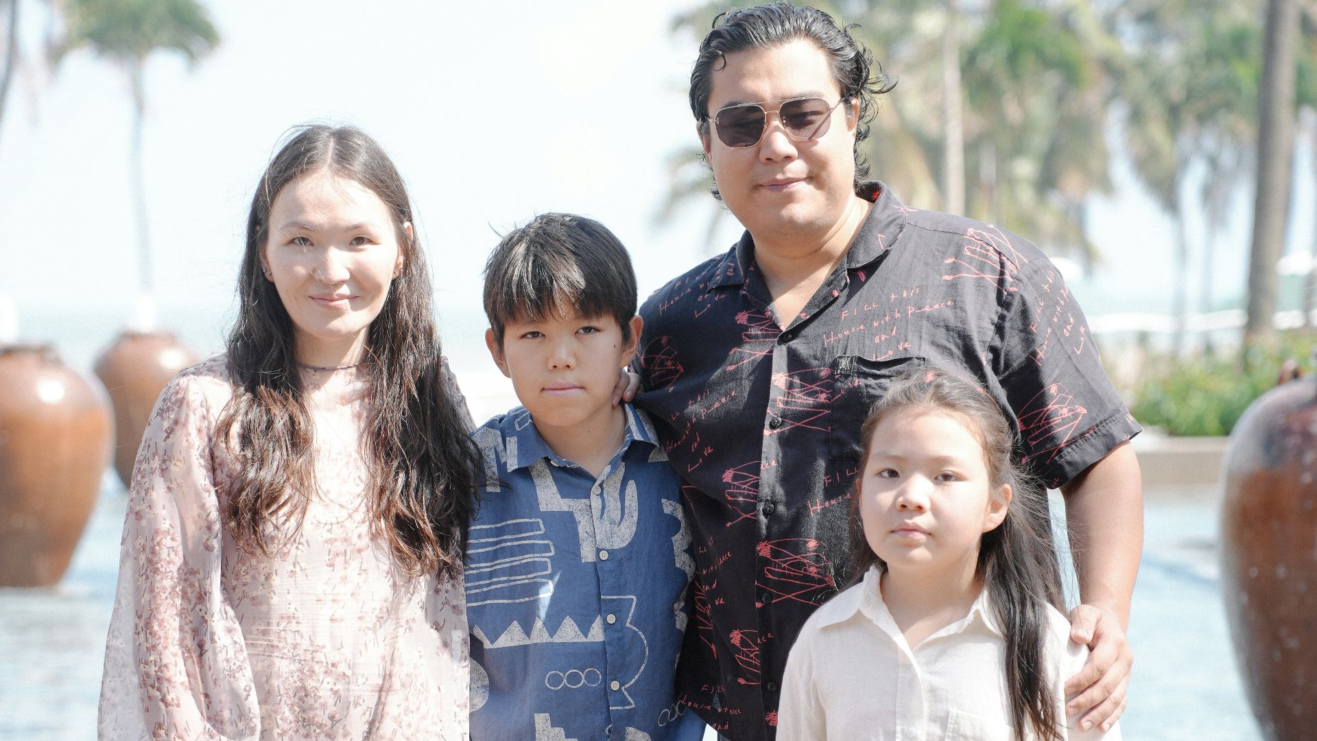 Family posing for a picture by the water.