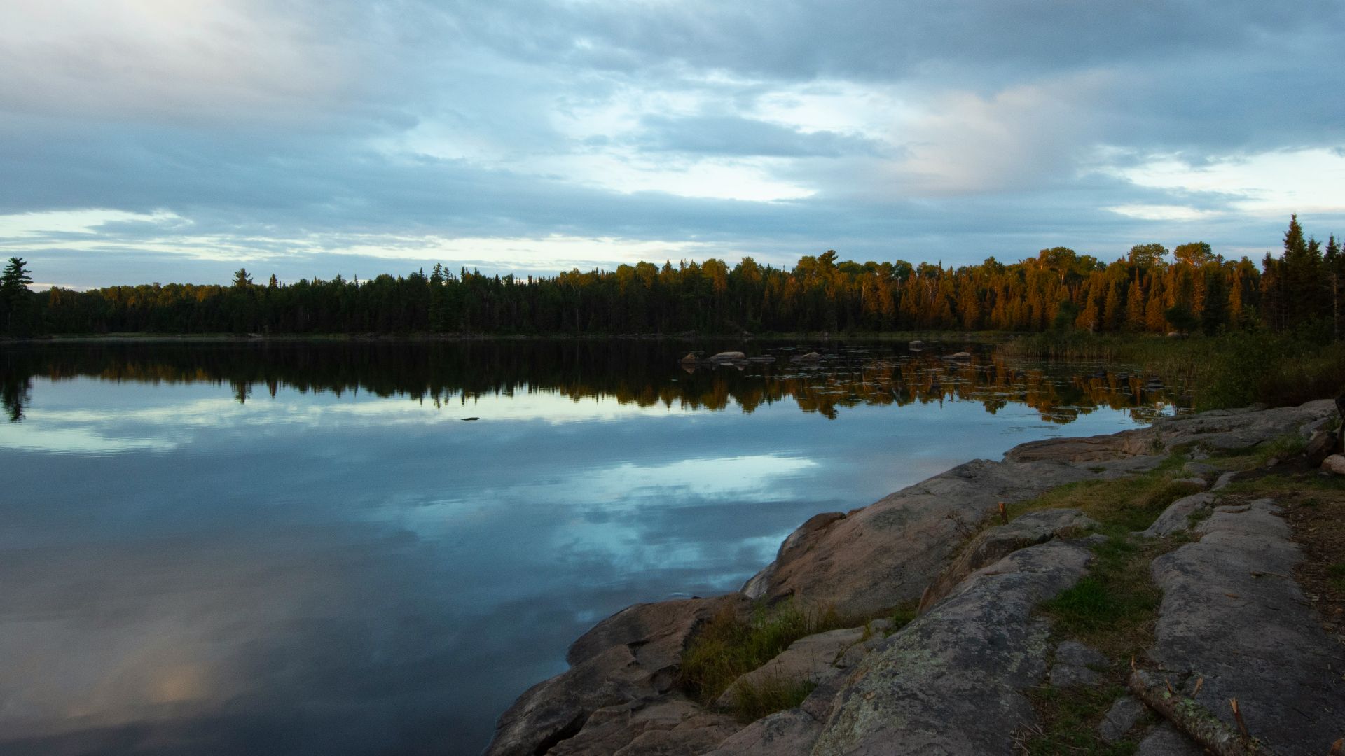 a body of water surrounded by rocks and trees