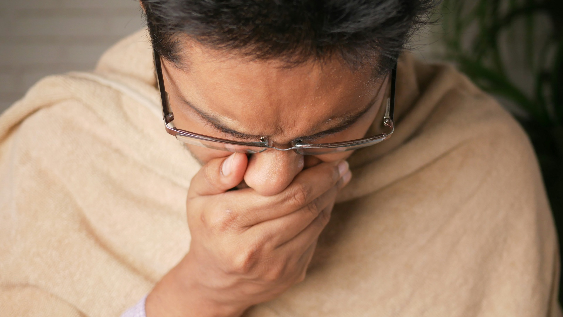 man in brown sweater wearing black framed eyeglasses