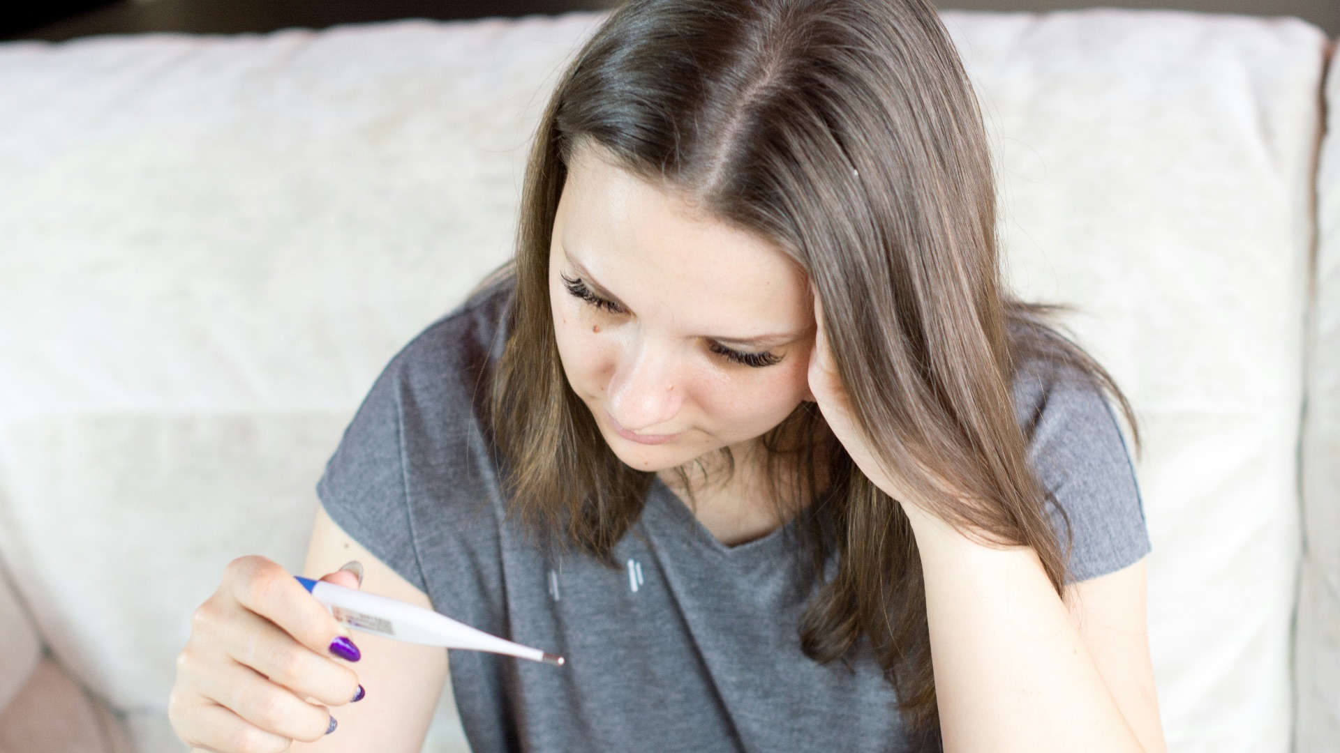 a woman sitting on a couch holding a pen and paper