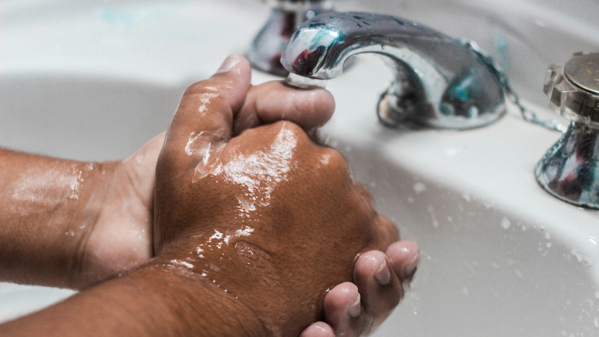 person washing hand on sink