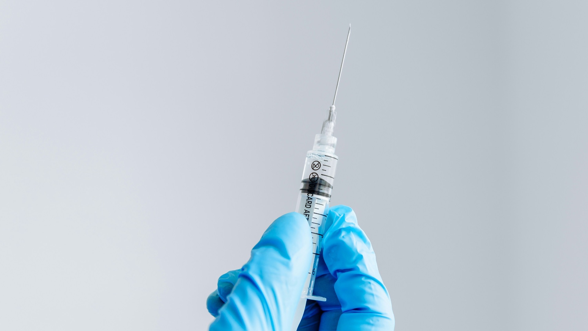 a hand in a blue glove holding a syquet