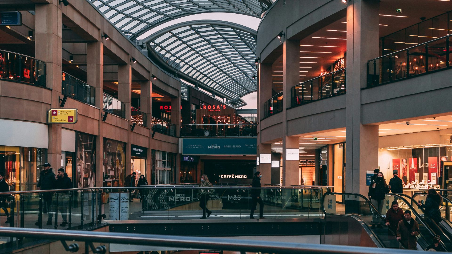 a group of people walking inside of a shopping mall